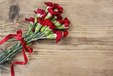 ahşap arka plan üzerinde kırmızı karanfil çiçek buketi. Üstten Görünüm,