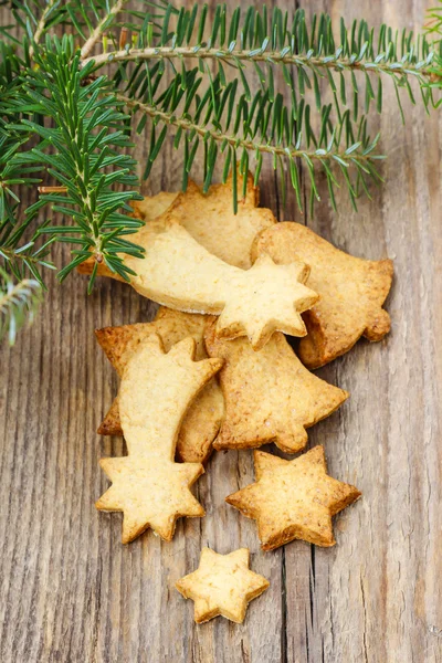 モミの枝の下で木製のテーブルの上のクリスマスのクッキー. — ストック写真