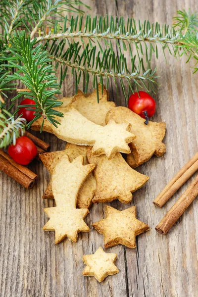 モミの枝の下で木製のテーブルの上のクリスマスのクッキー. — ストック写真