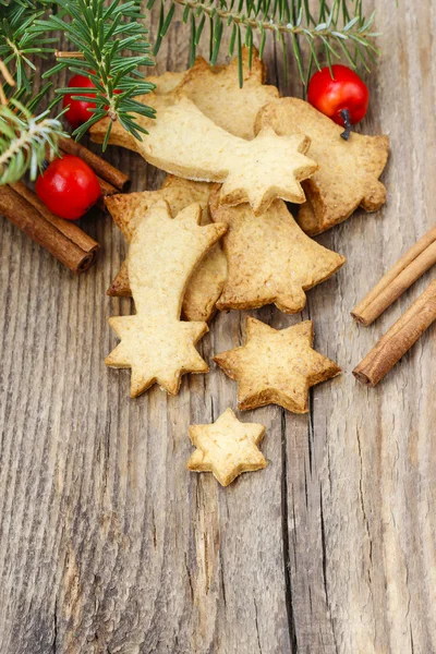 Christmas cookies on wooden table under fir branch. — Stock Photo, Image
