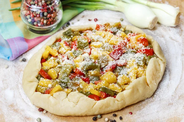 Vegetable galette on wooden kitchen board before baking. — Stock Photo, Image