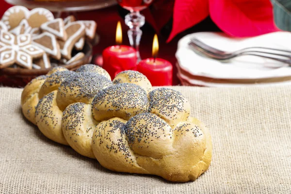 Festive bread on the table. Red christmas decorations in the bac — Stock Photo, Image