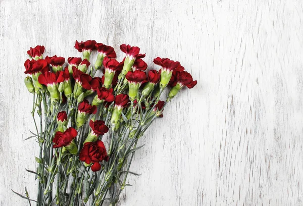 木製の背景に赤いカーネーションの花束。トップ ビュー, — ストック写真