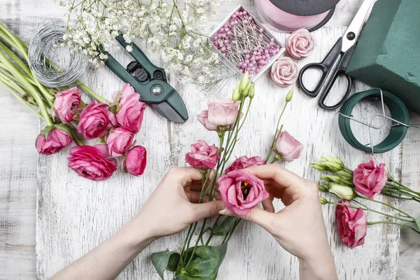 Florista no trabalho. Mulher fazendo belo buquê de eustoma rosa — Fotografia de Stock