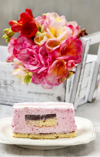 Layer cake with pink icing. Rustic box with freesia flowers in t — Stock Photo, Image