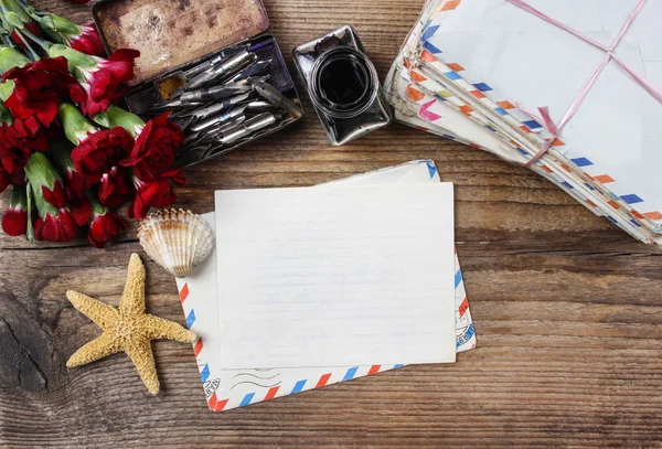 Writing a letter. Package of old letters and red carnation flowe — Stock Photo, Image