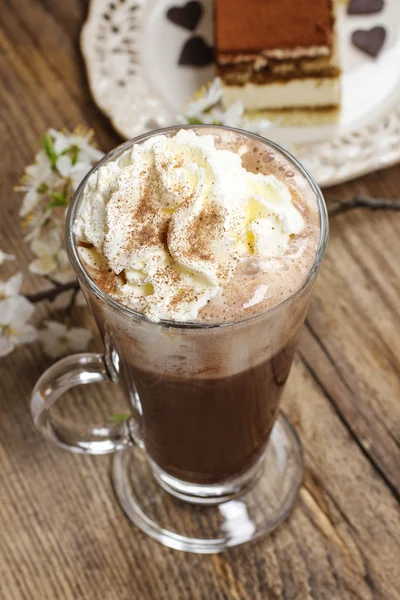 Irischer Kaffee auf Holztisch. Tiramisu-Kuchen und blühender Apfel — Stockfoto