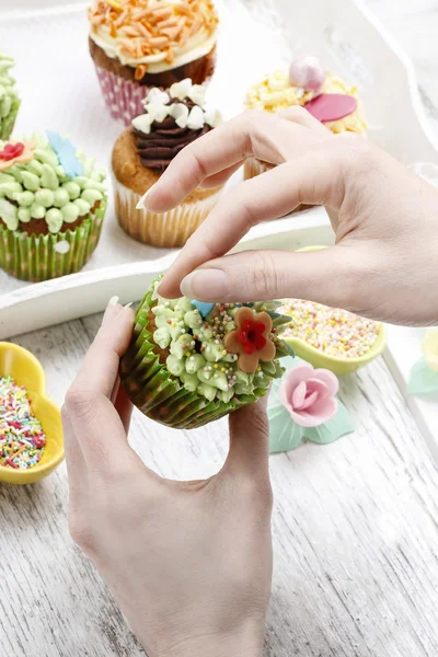 Woman decorates easter cupcakes — Stock Photo, Image