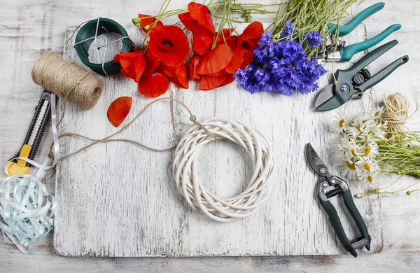 仕事で花屋。野生の花と枝編み細工品花輪を飾る女性 — ストック写真