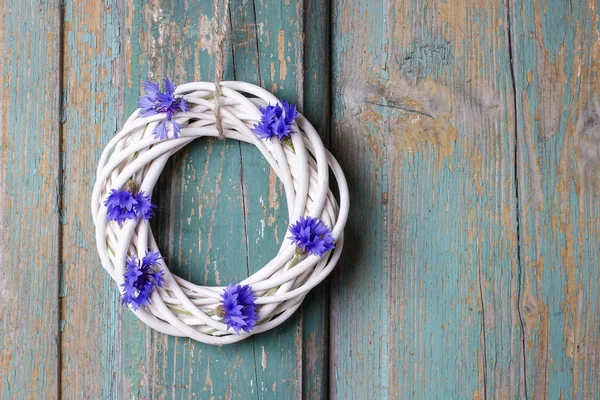 White wicker wreath decorated with cornflowers — Stock Photo, Image