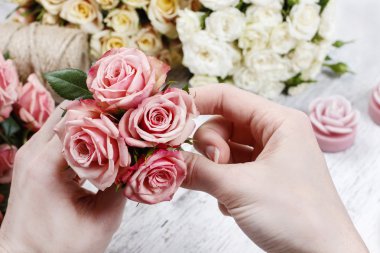 Çiçekçi iş başında. Kadın pembe gül buketi yapma