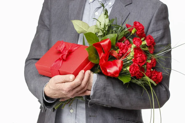 Uomo in possesso di bouquet di fiori di garofano e scatola rossa con grande bo — Foto Stock