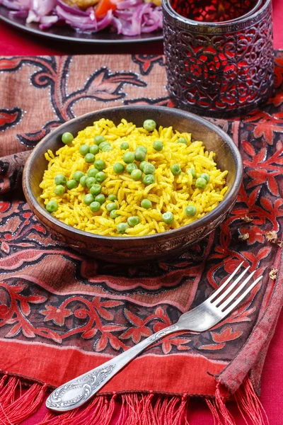 Indian cuisine: bowl of yellow rice with green peas — Stock Photo, Image