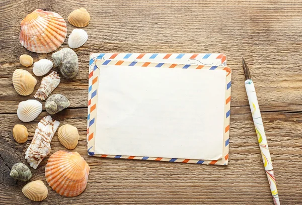 Het schrijven van een brief van vakantie. seashelles op een hout — Stockfoto