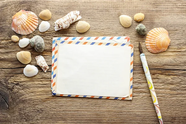 Writing a letter from holiday. Seashelles on a wood — Stock Photo, Image