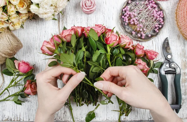 Florista en el trabajo. Mujer haciendo ramo de rosas rosadas —  Fotos de Stock