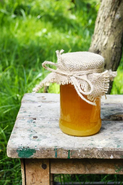 Tarro de miel y hermosos girasoles en el jardín —  Fotos de Stock