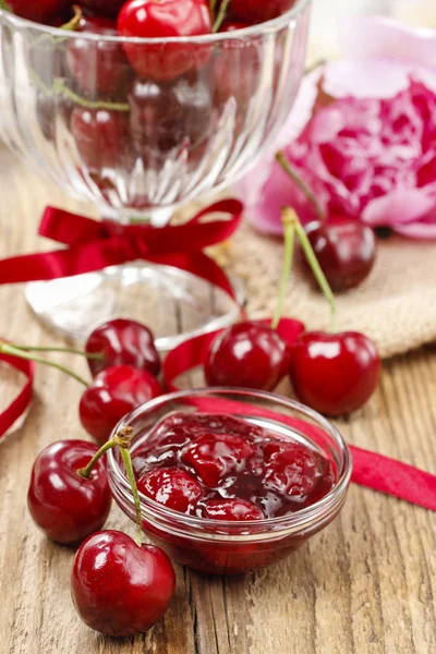 Bowl of cherry jam on wooden table and fresh cherries around — Stock Photo, Image