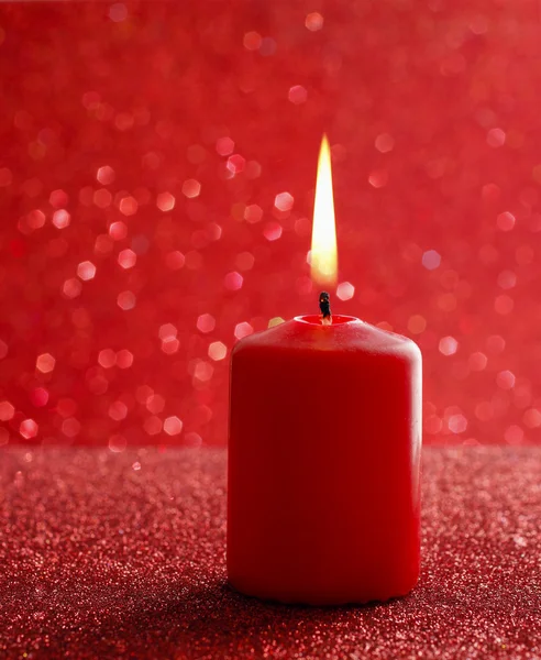 Red candle. Red glittering christmas lights. Blurred abstract ba — Stock Photo, Image