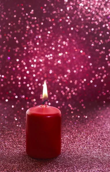 Red candle. Red glittering christmas lights. Blurred abstract — Stock Photo, Image