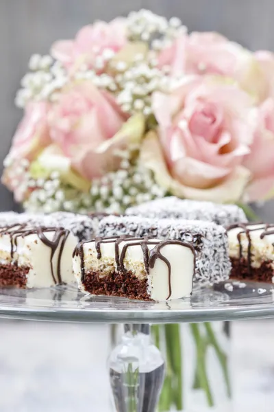Gâteaux au chocolat et massepain sur support de gâteau en verre . — Photo