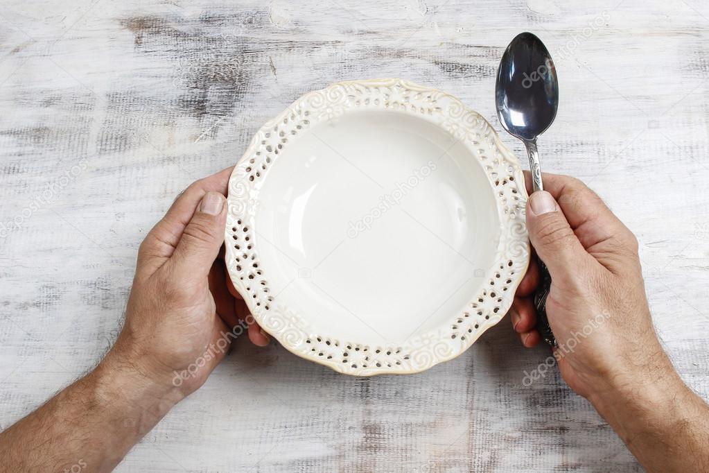Hungry man waiting for his meal over empty bowl