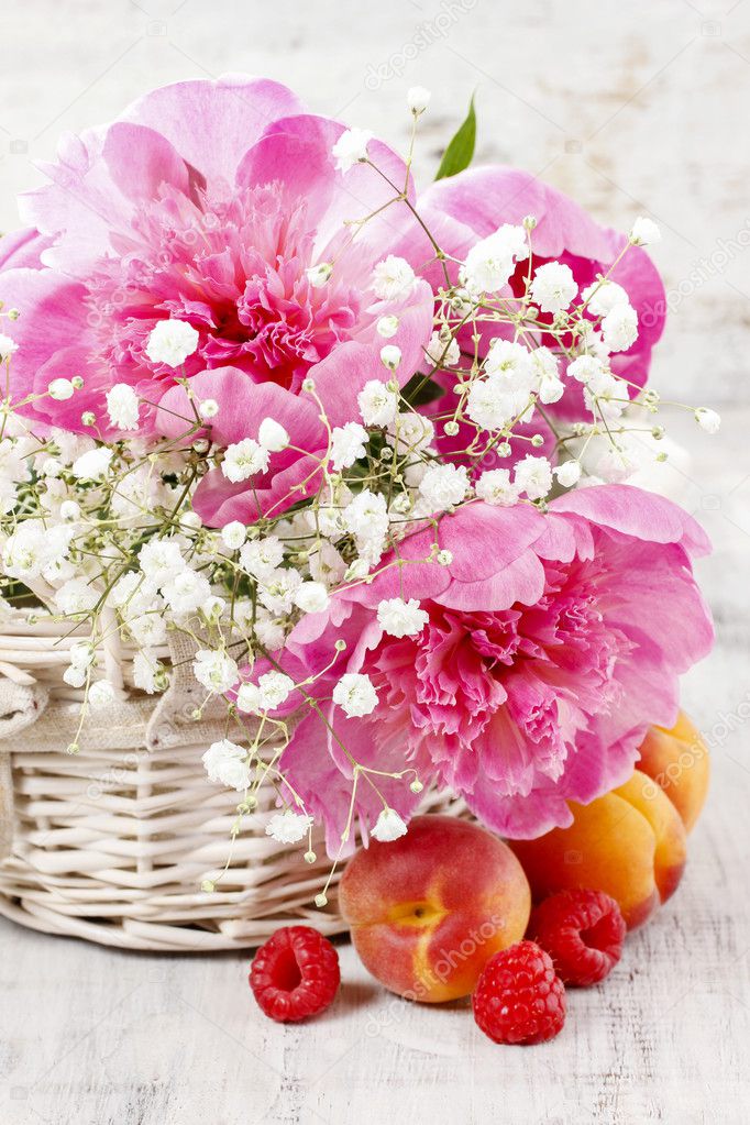 Basket of pretty pink peonies, white rustic background