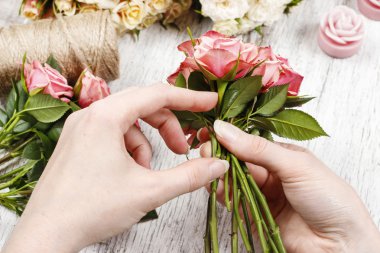 Çiçekçi iş başında. Kadın pembe gül buketi yapma