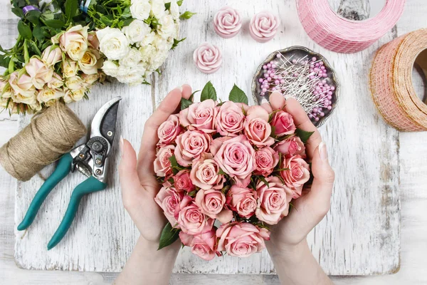 Florist bei der Arbeit. Frau macht Strauß aus rosa Rosen — Stockfoto