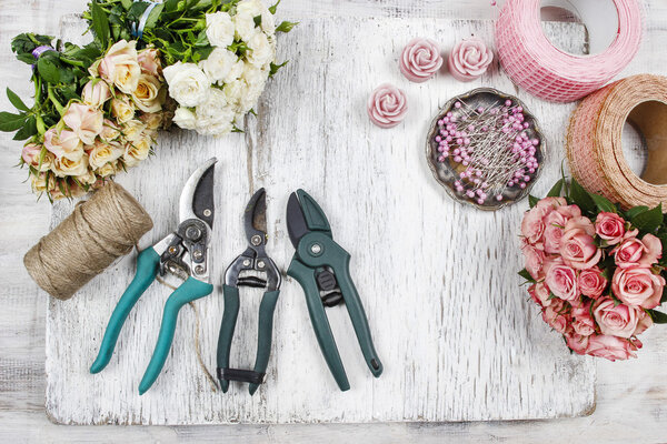 Florist at work. Woman making bouquet of pink roses