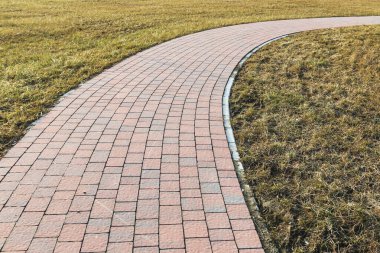Çimlerin ortasında kaldırımlı yürüyüş yolu. Grafiksel kaynaklar