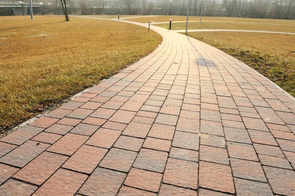 Çimlerin ortasında kaldırımlı yürüyüş yolu. Grafiksel kaynaklar