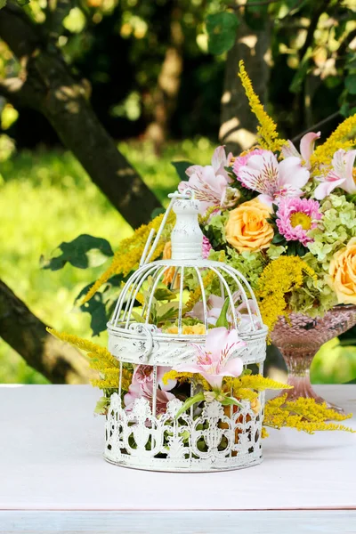 Yaz düğünü için modern masa süsü. Sersemletici bir düzende bir sürü yeşillik besteleniyor.