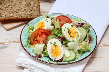 Marul, domates ve yumurtalı sağlıklı salata. Kahvaltı zamanı.