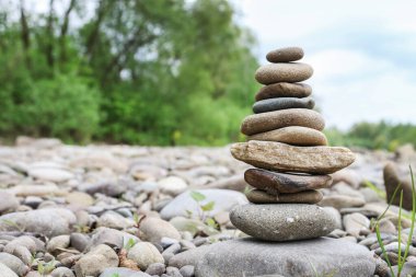 Taşları dengeleme sanatı. Kumsalda çakıl taşı piramidi. Grafiksel kaynaklar