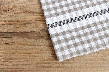 Damalı peçete ahşap bir masanın üzerinde yatıyor. Grafiksel kaynaklar