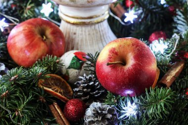 Geleneksel bir Noel çelenginde iki kırmızı elma. Şenlik Dekoru