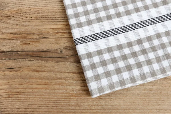 Damalı peçete ahşap bir masanın üzerinde yatıyor. Grafiksel kaynaklar