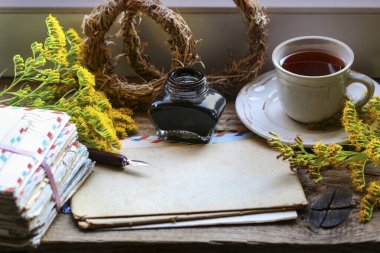 Masada bir yığın eski mektup ve mürekkep var. Retro biçimi