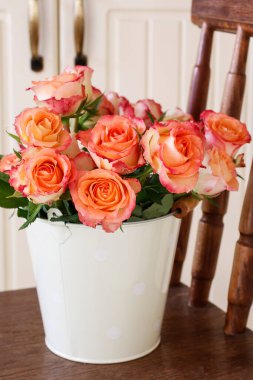 Süslü kovadaki güzel güller. Ev dekoru