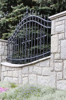 Taş ve demir elementlerden yapılmış bir çit. Dekor oluşturuluyor