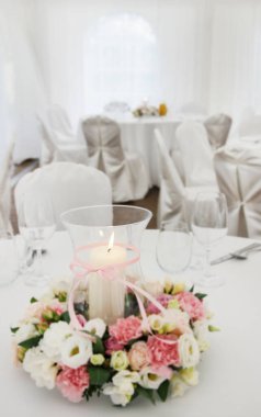 Düğün resepsiyonunda mum ve çiçek çelengi ile çiçek aranjmanı. Parti dekoru