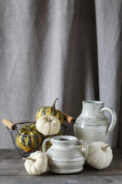 Home decoration in rustic style with white pumpkins (baby boo) and vintage ceramic vases. Autumn decor