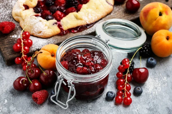 木のテーブルの上に新鮮な果物の間でチェリージャムの瓶 健康食品 — ストック写真