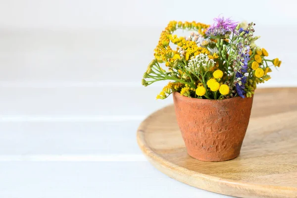 Bouquet of wild flowers in ceramic vase. Summer decor