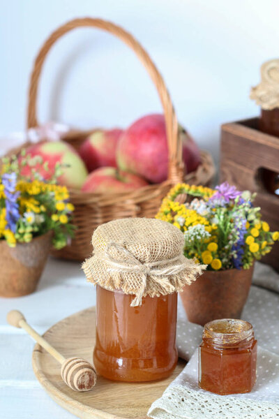 Jars with honey and bouquet of wild flowers on the table. Autumn decor