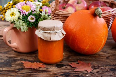 Reçel kavanozu, bir buket güz çiçeği ve balkabağı. Sonbahar dekoru