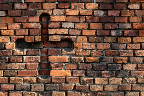 The sign of the cross carved into a brick wall. A symbol of strong faith.
