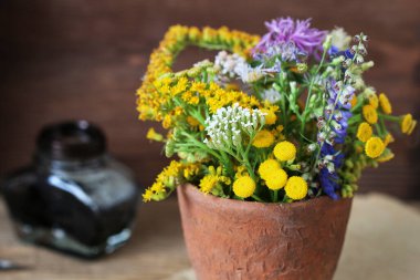 Seramik vazoda bir buket yabani çiçek. Sonbahar ev dekorasyonu
