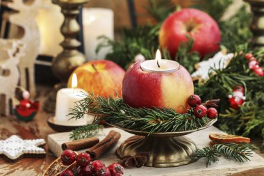 Traditional Christmas decoration with apples, cinnamon sticks and candles. Festive decor clipart